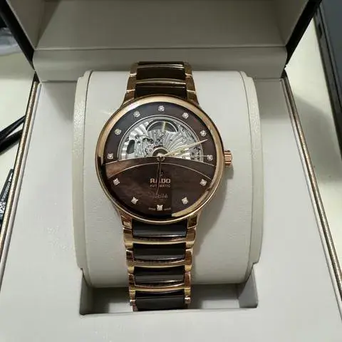 R-60283090 | R30028902 | ראדו יבואן רשמי בישראל | דגם סנטריקס סקלטון לגברים | אוטומטי עם 12 יהלומים בלוח פנינה חום | רוז גולד עם קרמיקה חומה | Centrix Automatic Diamonds Open Heart RADO R30028902